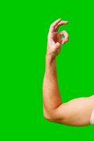 Hand Gesture Above Arm Against Bright Green Background photo