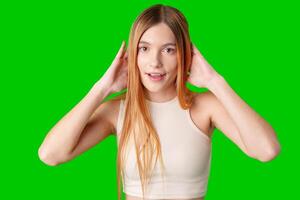 Young Woman With Surprised Expression in Front of Green Screen photo
