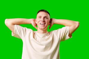 Man Reacting in Surprise With Hands on Head Against a Bright Green Background photo