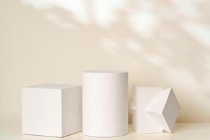 Three geometric shapes in soft white tones on a light background with gentle shadows photo