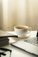 Modern Workspace With Laptop, Glasses, and Magazines photo