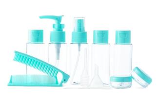 Clear cosmetic containers with turquoise lids and a comb arranged together on a white background photo