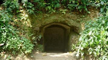 The entrance to a cave with a stone door in the middle. photo