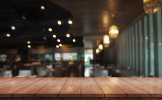 Empty wooden table top with lights bokeh on blur restaurant background. photo