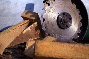 Circular saw blade cutting through logs with wood shavings and debris in a rustic workshop setting photo