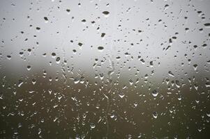 The raindrops on the window are small and numerous photo
