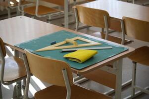 Classroom desk with math tools, ruler, and eraser on a cutting mat photo