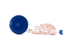 Coiled measuring tape with blue plastic case on white background, precision and measurement tools photo