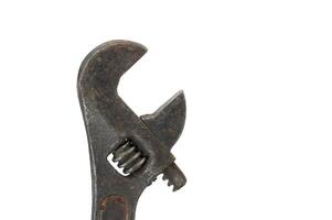 Close-up of an old and worn adjustable wrench with a rusty appearance isolated on a white background photo