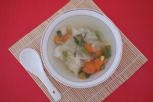 A bowl of vegetable soup on a table photo