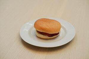 Hamburger bun on a white plate. Close up. photo