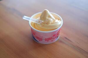 ice cream in paper cup on wood table background. soft focus. photo