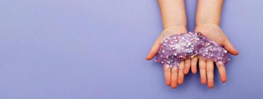 Making slime at home. child stretching colorful slime. DIY concept. Very Peri photo