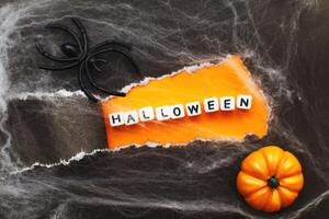 curl of torn black paper on orange background. halloween sale concept photo