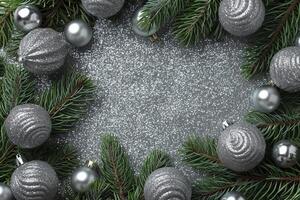 Christmas decoration with fir branches and silver balls on gray background. Top view with copy space. photo