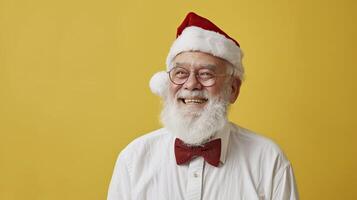 Portrait of senior man in Santa Claus hat and glasses on yellow background. photo