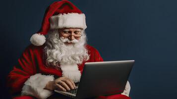 Santa Claus using a laptop on a blue background. Christmas and New Year. photo