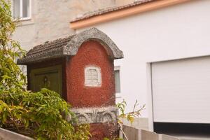 Close-up of an old stone house mailbox on the fence of one of the houses in Coimbra, Portugal. Concept of cozy home things for a country house photo