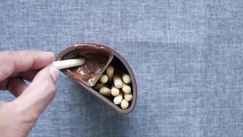 A person is holding a chocolate bar with nuts in it video