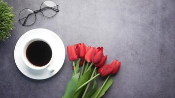 Cup of coffee and red tulips on a gray background video