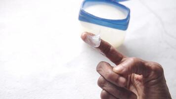 A person holding a container of cream on a table video