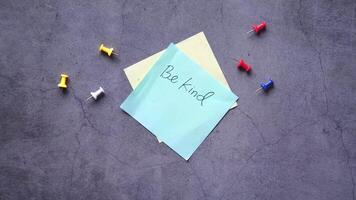 Be kind note on a sticky note on concrete background video
