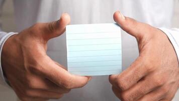 A man holding a piece of paper with a note on it video