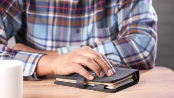 A man is sitting at a table with a notebook and coffee video