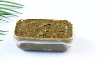 A small container of green paste with a leaf video