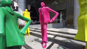 A group of colorful statues of people in front of a building video