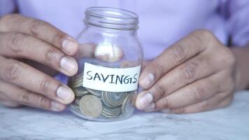 A man holding a jar with savings written on it video