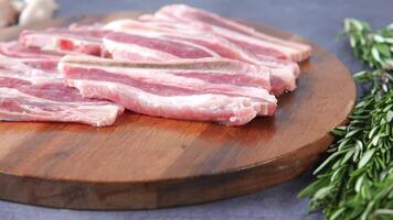 Raw pork on a cutting board with rosemary video