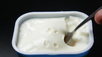 A spoon is being used to scoop out yogurt from a container video