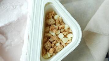 A container of ice cream with a spoon and some cereal video