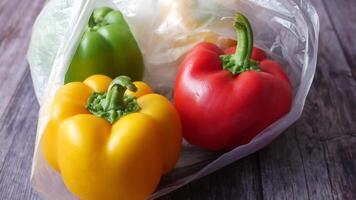 Three peppers in a plastic bag on a wooden table video