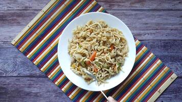 A plate of noodles with vegetables and meat on it video