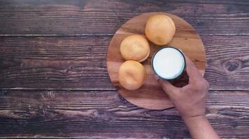 A person holding a glass of milk and a bowl of buns video