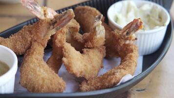 Fried shrimp with dipping sauce on a black plate video