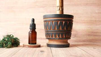 A wooden vase with a bottle of essential oil next to it video