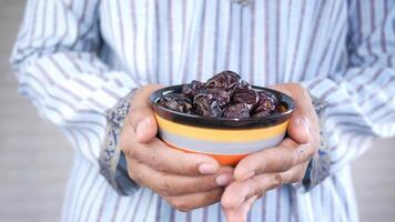 A man holding a bowl of dates video