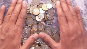 A person's hands are holding up a pile of coins video