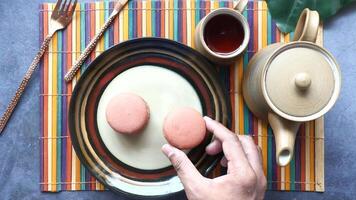 A person holding a plate with two macarons on it video
