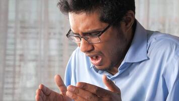 A man with glasses and a shirt is making a face video