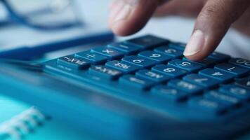 A person is using a calculator to calculate the numbers video