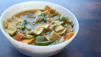 A bowl of soup with vegetables and noodles in it video