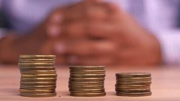 A man is sitting in front of stacks of coins video