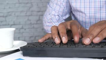 A man typing on a keyboard with a cup of coffee video