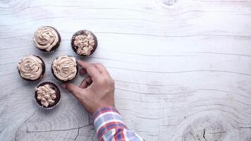 A person is holding a cupcake with frosting on it video