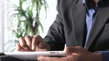 A man in a suit is using a tablet computer video