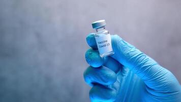 A person holding a small vial of a vaccine video